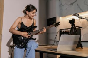 Pessoa tocando guitarra elétrica em estúdio caseiro com iluminação moody, mostrando como aprender guitarra traz foco, criatividade e escape emocional
